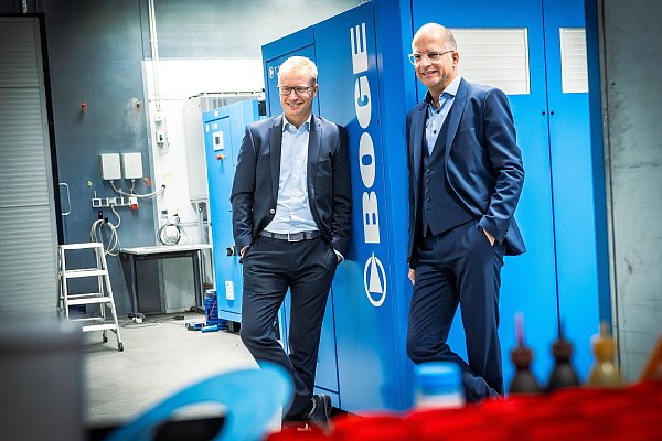 Boge-Geschäftsführer Björn Six und Sebastian Göbel lehnen an einem ihrer Kompressoren mit Turbo-Antrieb. - © Barbara Franke
