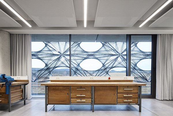 Die hölzerne Werkbank erscheint in dem modernen Gebäude fast schon als eklektischer Akzent. - © Hörmann/Laura Thiesbrummel
