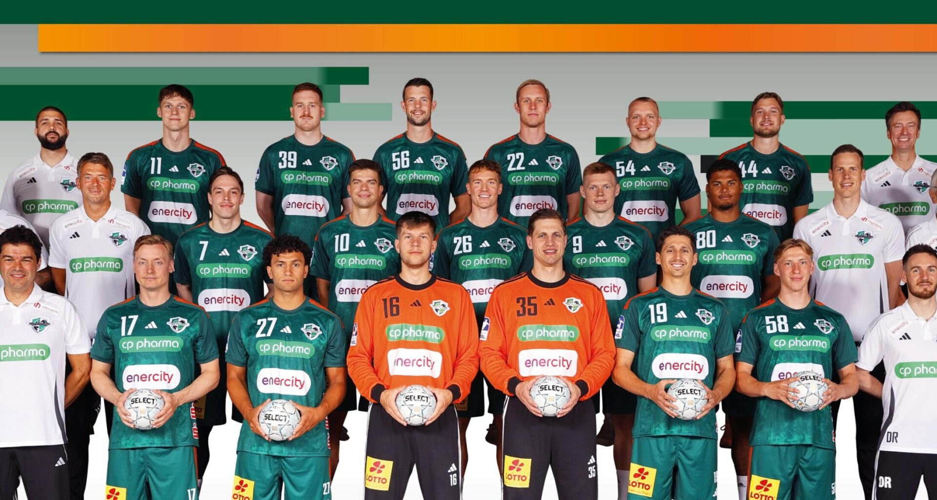 Eine Handballmannschaft der Männer posiert für ein Gruppenfoto in grünen Trikots mit Mitarbeitern in weißen Hemden, die Handbälle halten, vor einem Hintergrund mit grünen und orangefarbenen Streifen.