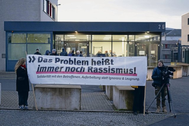 Teilnehmer einer Kundgebung stehen vor dem Oberlandesgericht und erklären: »Das Problem heißt immer noch Rassismus«.