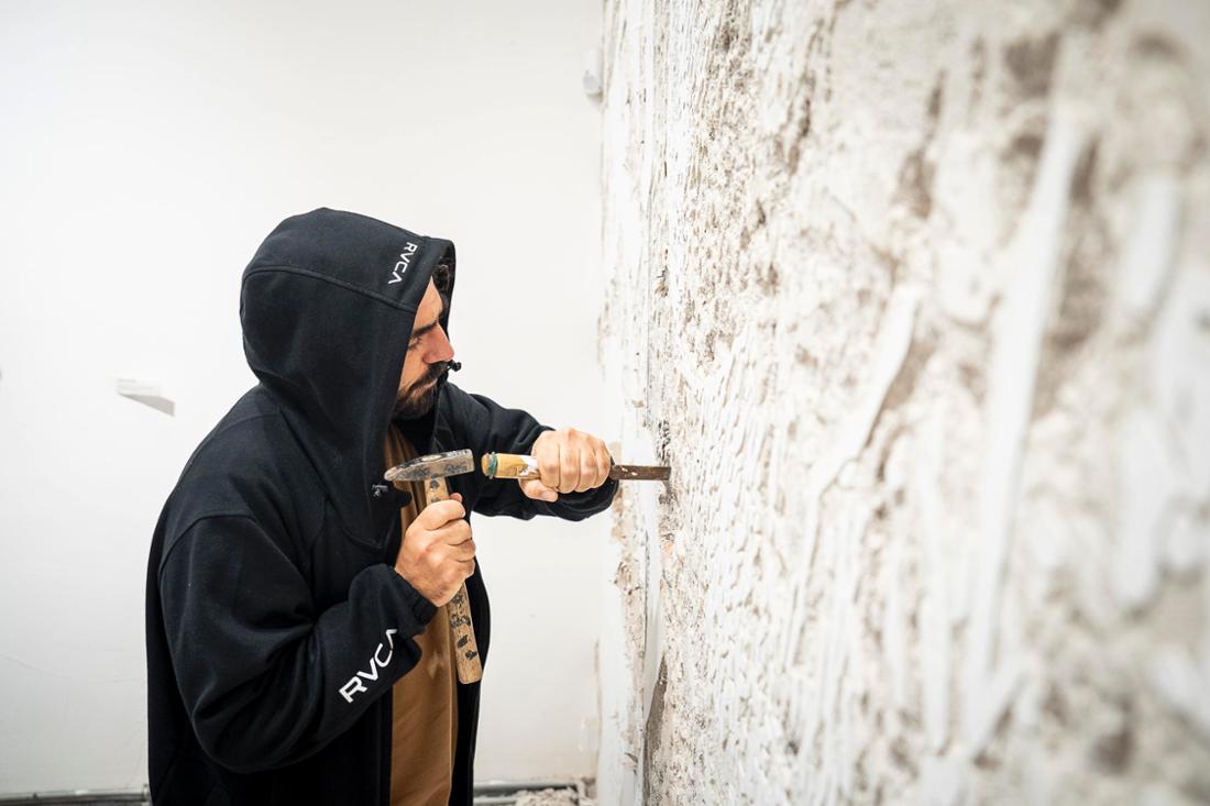 Radikal: In eine Wand im Muca München hat Vhils ein Kunstwerk gemeißelt.