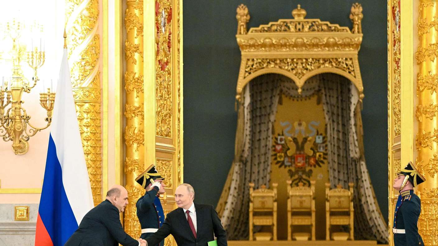In this pool photograph distributed by the Russian state agency Sputnik, Russia's President Vladimir Putin shakes hands with Prime Minister Mikhail Mishustin during a meeting of the Council for Strategic Development and National Projects at the Kremlin in Moscow on December 8, 2025. (Photo by Kristina Kormilitsyna / POOL / AFP)