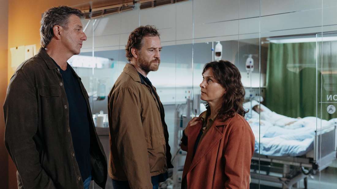 Dr. Martin Gruber (Hans Sigl) steht mit Clara Meindl (Kathrin von Steinburg) und Jakob Meindl (Tom Radisch) vor dem Krankenzimmer ihrer Kinder Mia Meindl (Finja Leonie Meyer) und Noah Meindl (Levi Brandl). 