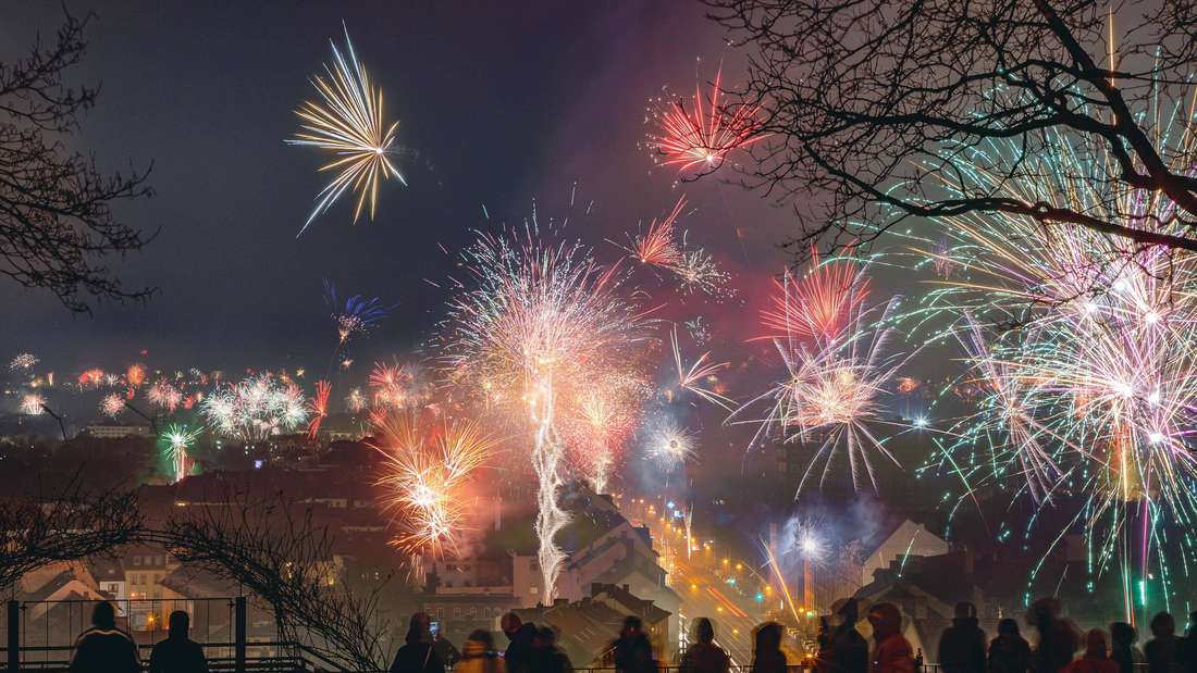 Menschen feiern zum Jahreswechsel 2025 auf dem Kasseler Weinberg und genießen das Silvesterfeuerwerk in der Südstadt.