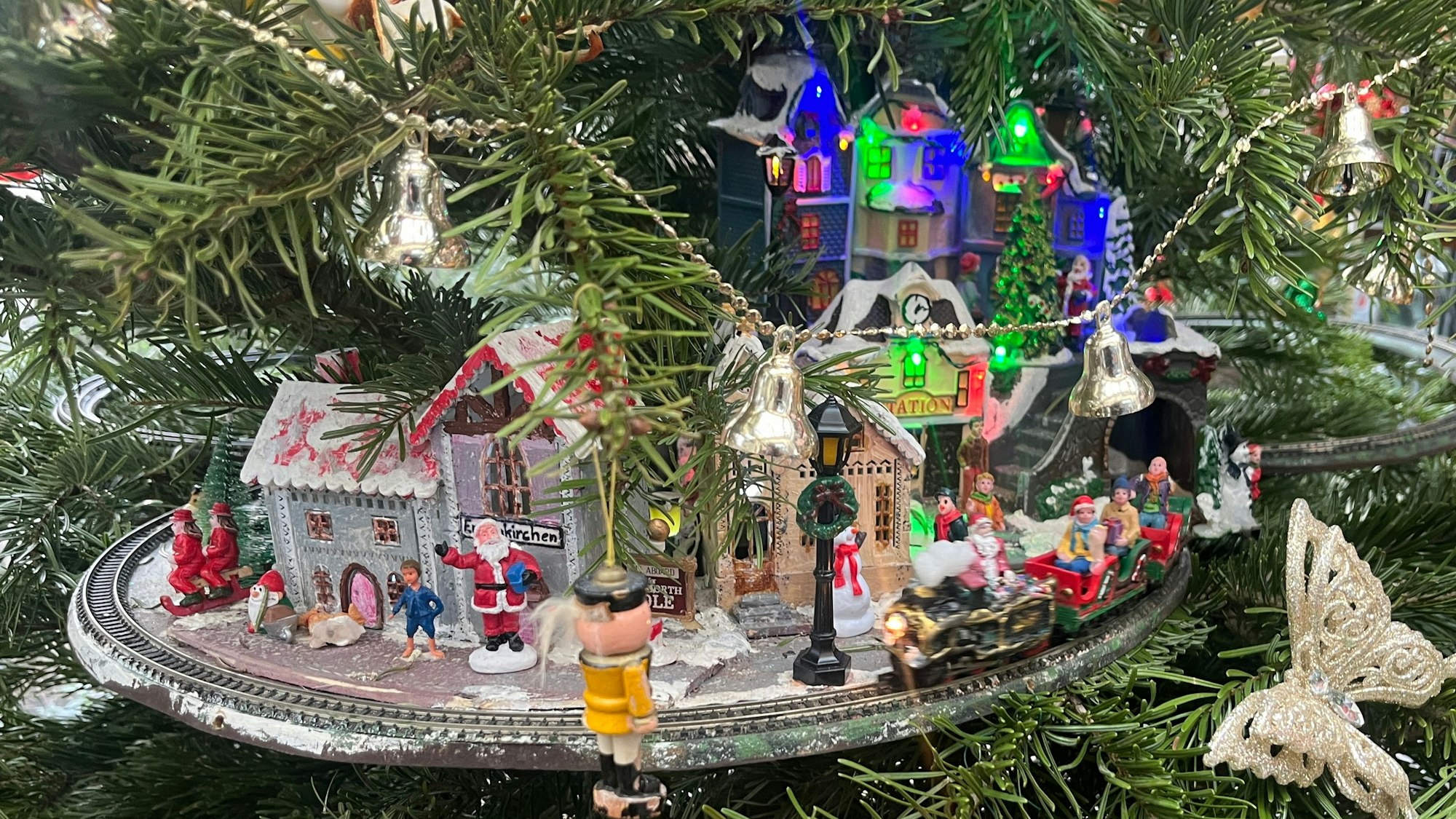 Auf drei Kreisen rattert die Eisenbahn mit Weihnachtsmann als Lokführer durch die Nadeln.