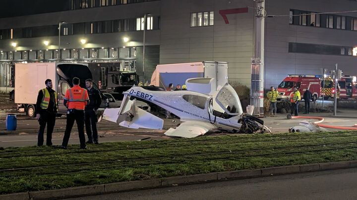Kleinflugzeugabsturz auf einer Strasse bei Nacht, umgeben von Einsatzfahrzeugen und Rettungskräften.