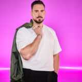 Marvin Raab vor einem pinken Hintergrund.