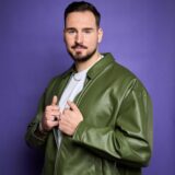 Ein junger Mann schaut selbstbewusst in die Kamera.