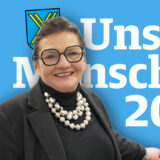 Martina Tielker vor der Aufschrift „Unsere Menschen 2025“