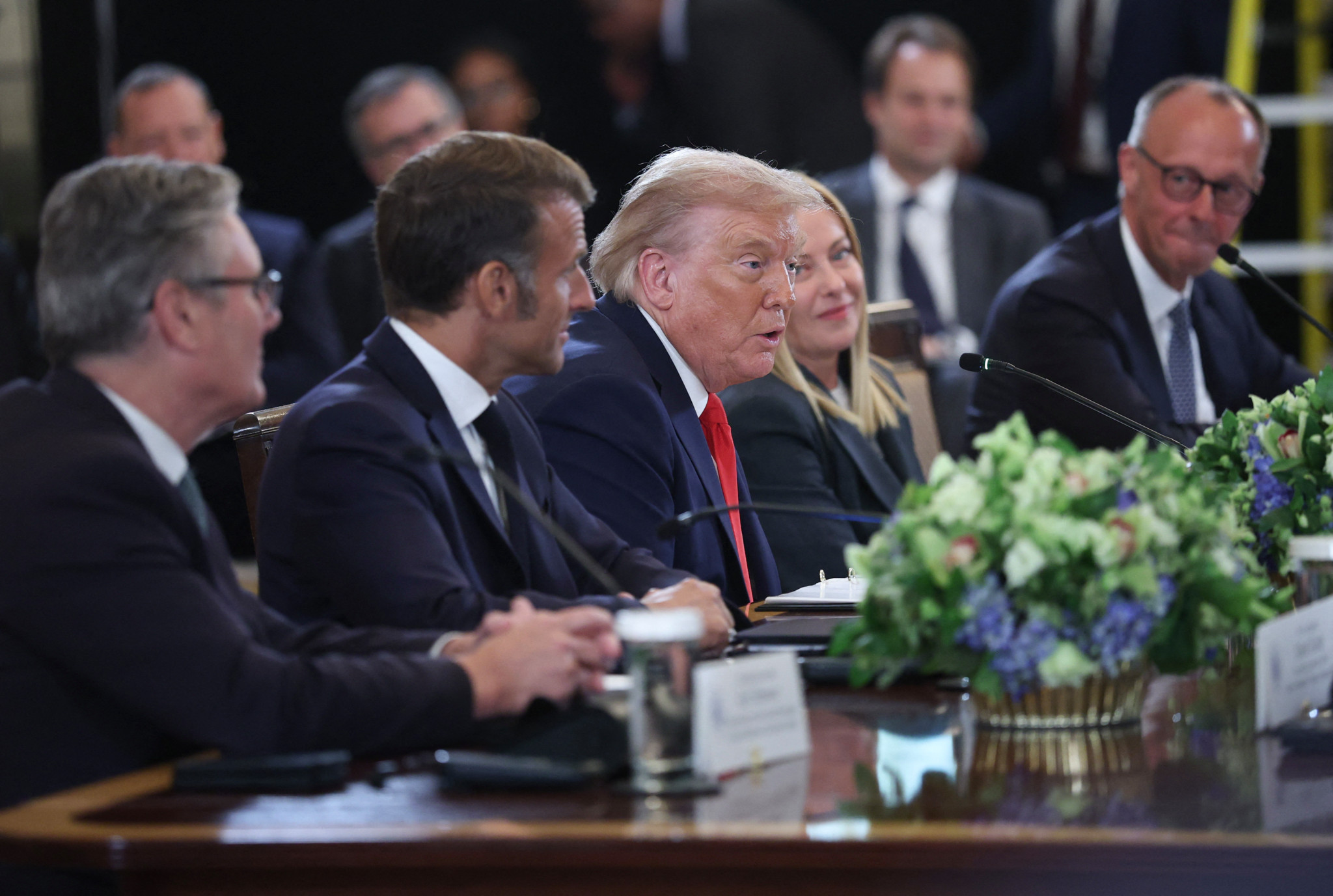 US-Präsident Donald Trump sitzt mit europäischen Politikern an einem Tisch, darunter der britische Premierminister Keir Starmer, der französische Präsident Emmanuel Macron, die italienische Premierministerin Giorgia Meloni und der deutsche Kanzler Friedrich Merz.