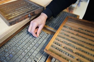 Eine Mitarbeiterin hält in der Werkstatt der Buchbinderei Fritz Castagne Heißprägeschriften in der Hand.