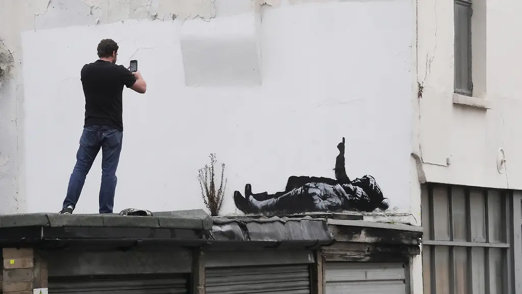 Banksy-artwork-A-person-takes-a-photograph-of-a-piece-of-graffiti-artwork-depicting-two-children-which-could-be-the-work-of-street-artist-Banksy-in-Bayswater-in-central-London-Picture-date-Monday-December-22-2025