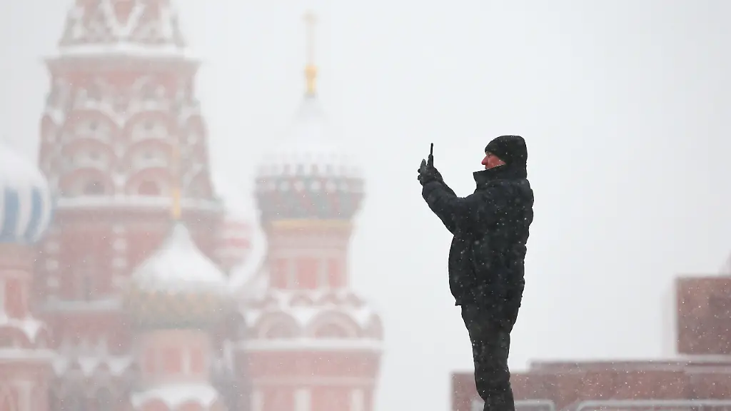 DIESES-FOTO-WIRD-VON-DER-RUSSISCHEN-STAATSAGENTUR-TASS-ZUR-VERFUeGUNG-GESTELLT-RUSSIA-MOSCOW-DECEMBER-10-2023-A-man-takes-pictures-in-Red-Square-with-St-Basil-s-Cathedral-in-the-background