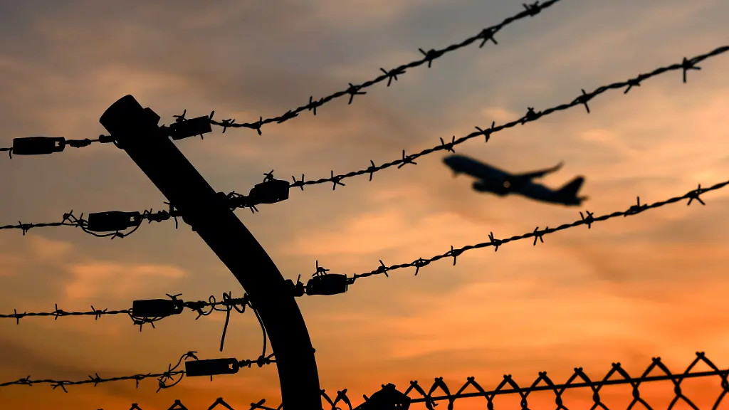 Ein-Flugzeug-startet-am-Flughafen-Koeln-Bonn-gesehen-durch-Stacheldraht-ausserhalb-des-Rollfelds-Der-Begriff-der-Remigration-hat-im-Wahlkampf-fuer-heftige-Debatten-gesorgt-Themenbild-Symbolbild-Koeln-09-03