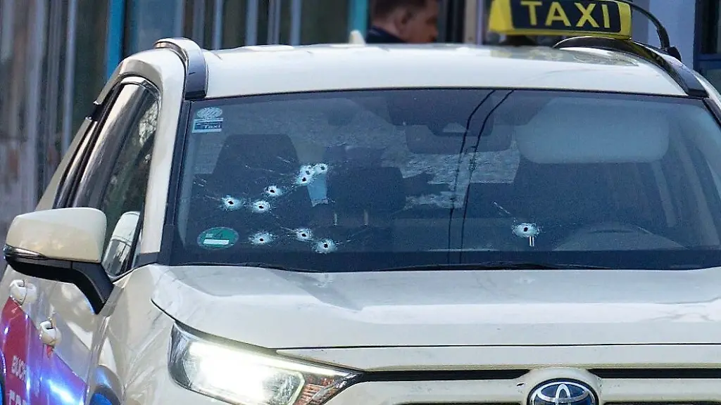 Ein-Taxi-mit-Schussloechern-in-der-Frontscheibe-steht-auf-der-Strasse-Vermutlich-durch-Schuesse-soll-in-der-Duesseldorfer-Innenstadt-ein-Mensch-verletzt-worden-sein