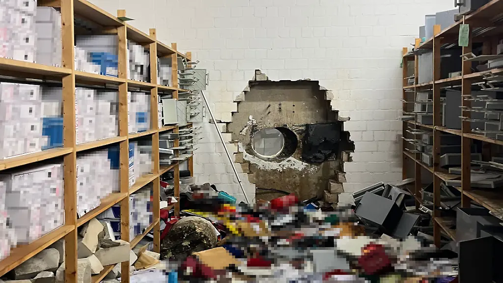 Ein-grosses-Loch-ist-in-der-Wand-eines-Vorraums-zum-Tresorraums-dahinter-einer-Sparkasse-zu-sehen-Einbrecher-haben-sich-mit-Hilfe-eines-grossen-Bohrers-Zugang-zum-Tresorraum-verschafft-Dort-durchsuchten-sie-die-Wertschliessfaecher