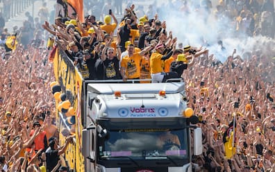 Dynamofans feiern am Terrassenufer den Aufstieg in die 2. Bundesliga und verfolgen einen Bus mit der Mannschaft. 