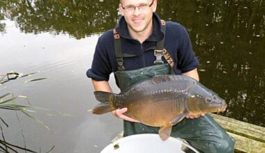 Man hält Karpfen in den Händen