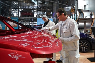 Mitarbeiter Heiko Lehmann unterschreibt auf dem letzten VW ID.3, der in Dresden montiert wird.