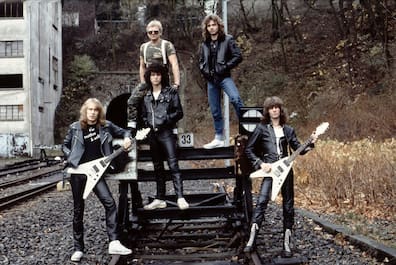 Die erste Generation der Musiker von Accept stehen dort, wo heute die Korkenziehertrasse am Nordbahnhof verläuft. Links ist das ehemalige Probenraumhaus „Blaues Haus“ zu sehen, welches heute den Namen Monkeys trägt.