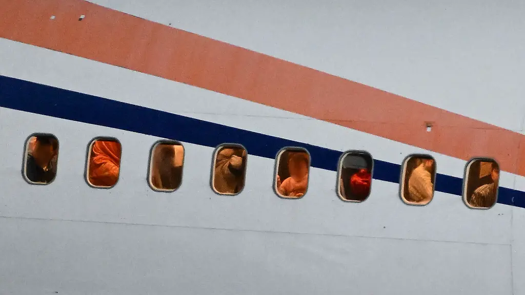 Passagiere-schauen-auf-dem-Flughafen-Leipzig-Halle-aus-den-Fenstern-eines-zuvor-gelandeten-Flugzeugs-Mit-der-Maschine-sind-ehemalige-Ortskraefte-deutscher-Institutionen-aus-Afghanistan-in-Leipzig-gelandet-Per-Flugzeug-werden-ehemalige-Ortskraefte-sowie-besonders-gefaehrdete-Menschen-etwa-Menschenrechtsanwaelte-oder-Frauenrechtlerinnen-nach-Deutschland-geholt