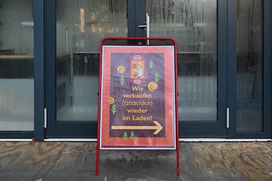 Vor dem Container, der in der Zwischenzeit als Verkaufsstelle aushalf, weist dieses Schild auf die neuen Entwicklungen hin.