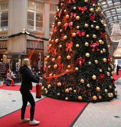 Protest der Letzte Generation in Leipzig. Aktivisten besprühen den Weihnachtsbaum in der Mädlerpassage mit orangener Farbe.