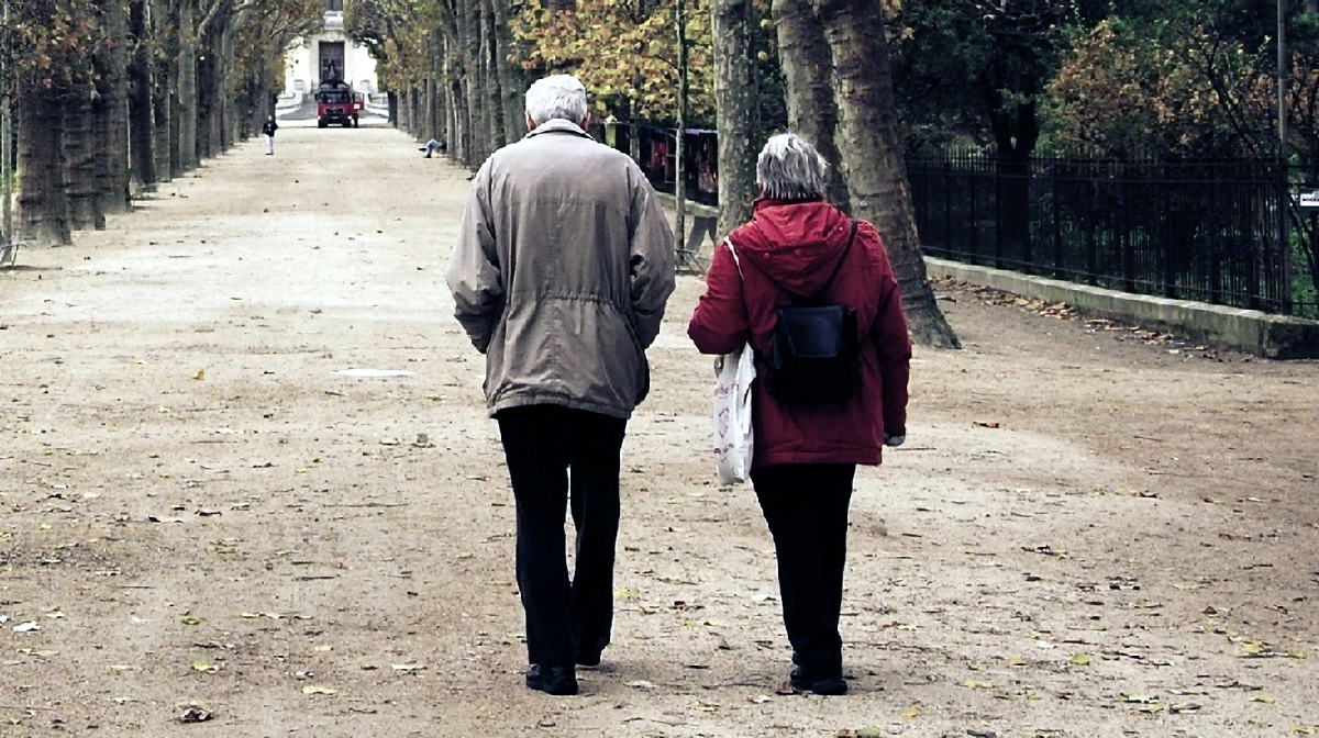 Bildbeschreibung: Ein Seniorenpaar das draußen spazieren geht.