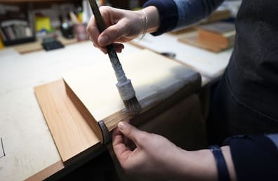 Eine Mitarbeiterin restauriert in der Werkstatt der Buchbinderei Fritz Castagne ein Buch.