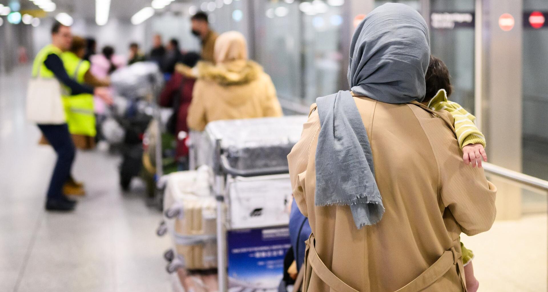 Afghaninnen und Afghanen aus den Bundesaufnahmeprogrammen stehen im Flughafen Hannover.