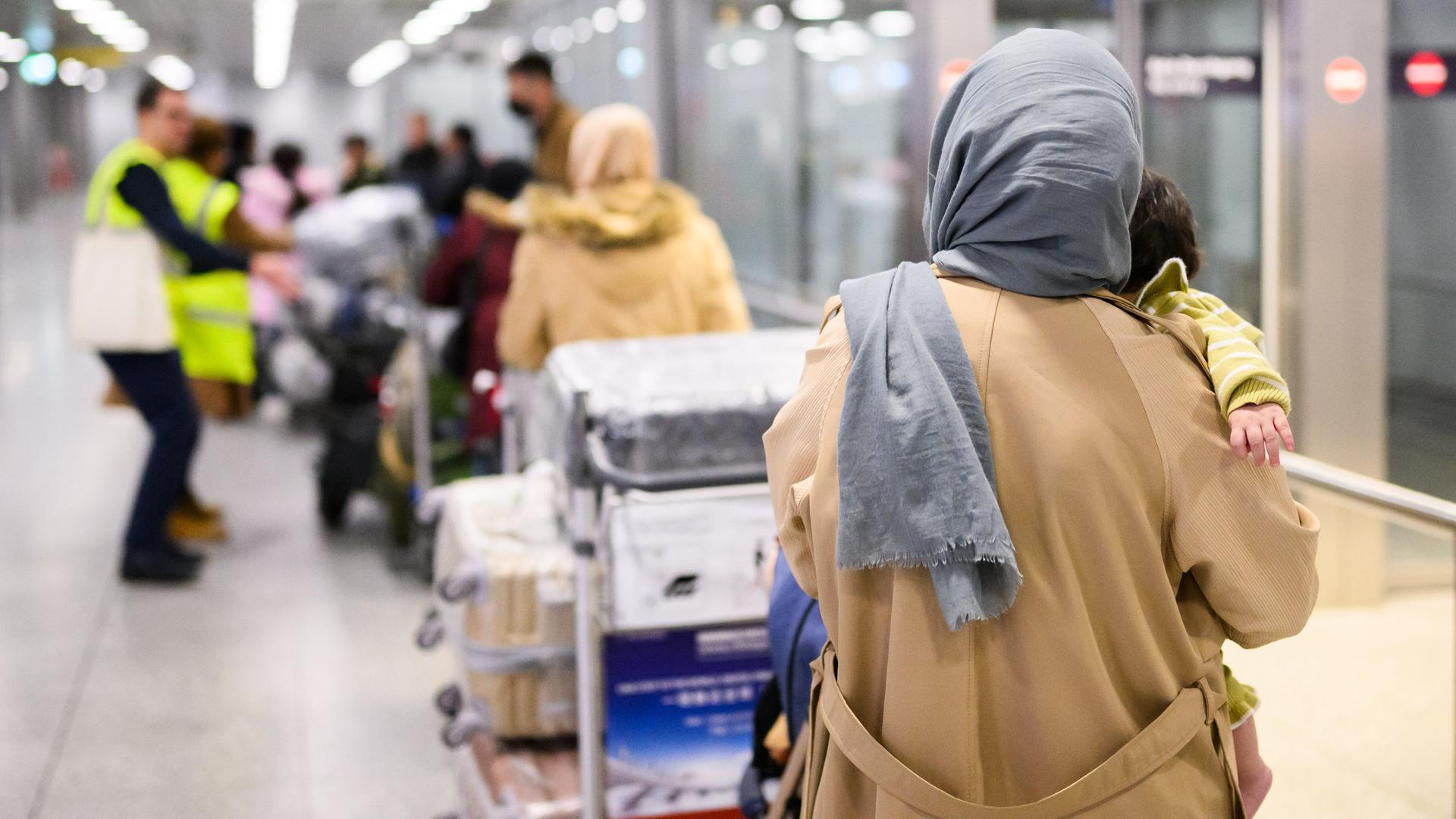 Afghaninnen und Afghanen aus den Bundesaufnahmeprogrammen stehen im Flughafen Hannover. 