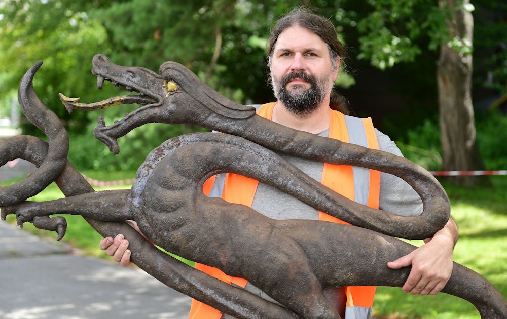 Schmied und Restaurator Johannes Pilz mit dem Drachen vor der Restaurierung.