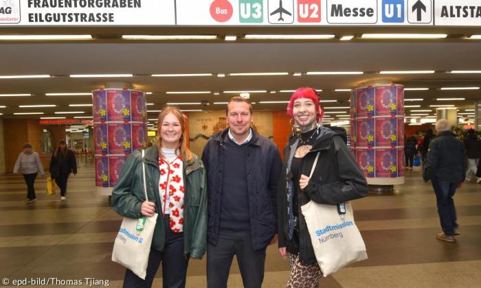 Drei Menschen am Bahnhof