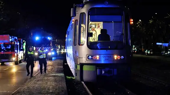 Polizeibeamte stehen nach einem Unfall neben einer Stadtbahn in Hannover.