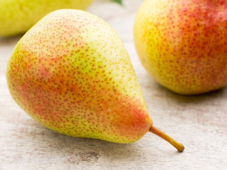 Close up einer Birne mit rot gelber Schale. | © Getty Images/ gitusik via Canva.com