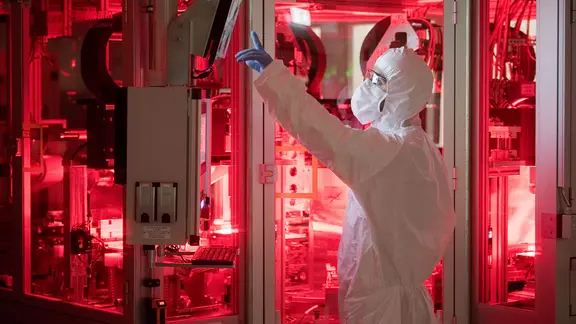 Ein Mitarbeiter von Volkswagen steht in einem Reinraum zur Produktion von Batteriezellen im VW Werk Salzgitter.