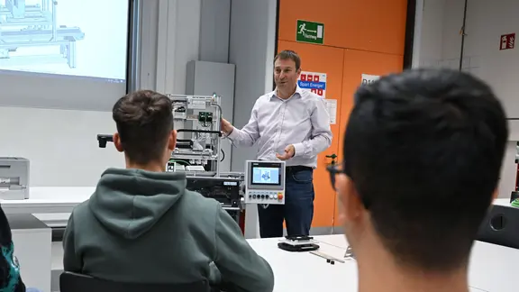 Ein Lehrer spricht vor Schülern einer Berufsschule.