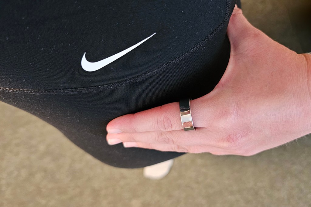 Smart Ring an Hand, die sich an Sporthose stützt