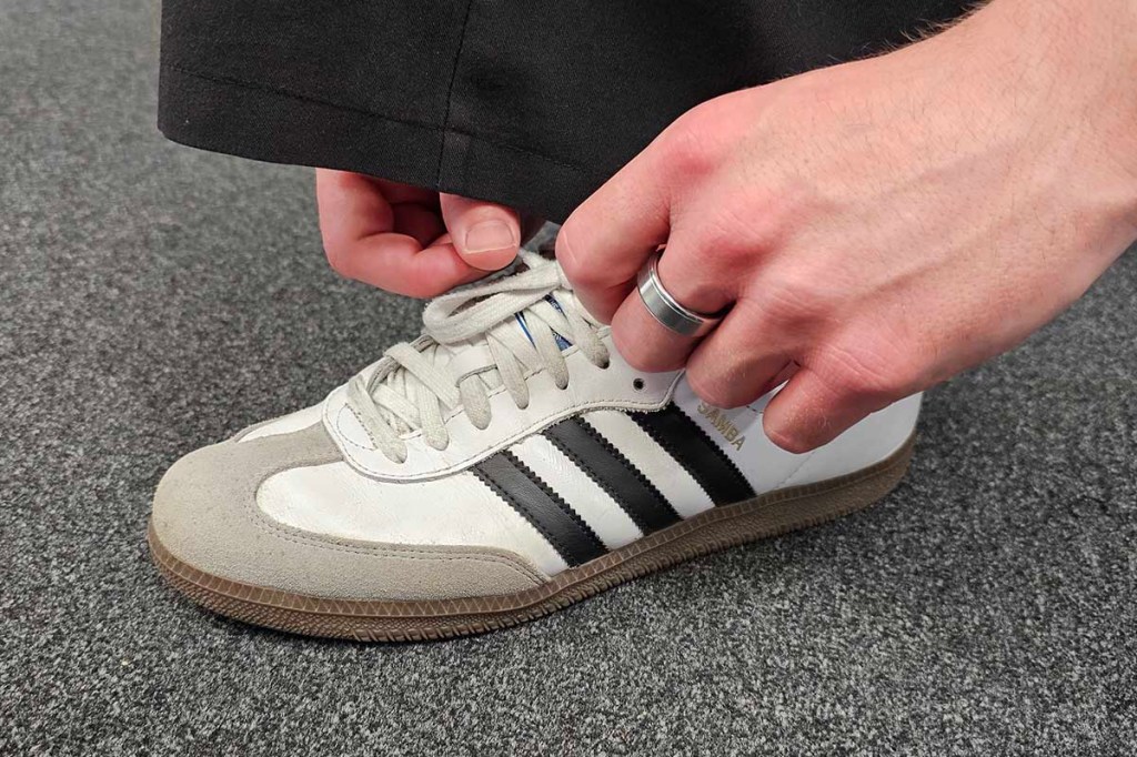 Smart Ring an einer Hand, die einen Schuh zubindet