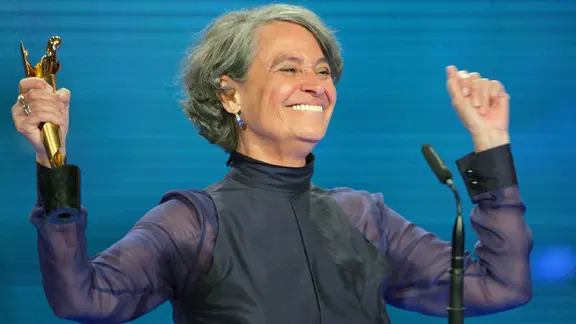 Monica Bleitreu jubelt mit der Trophäe des Deutschen Filmpreises in der Hand.