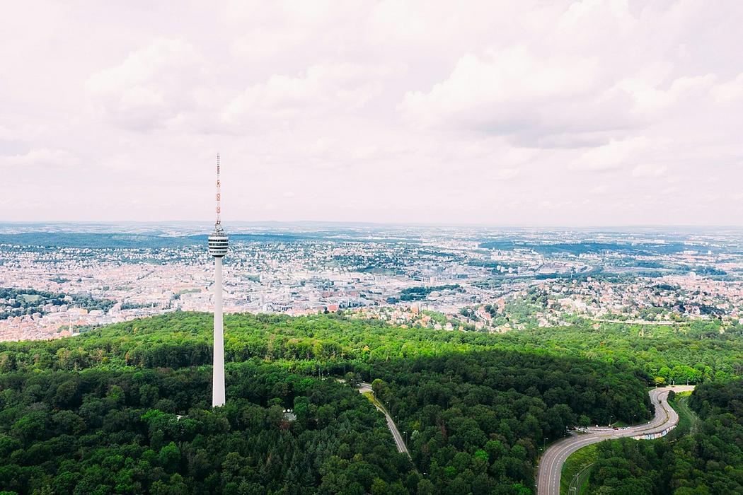 Blick von einem grünen Hügel mit einem Fernsehturm auf die Stadt Stuttgart