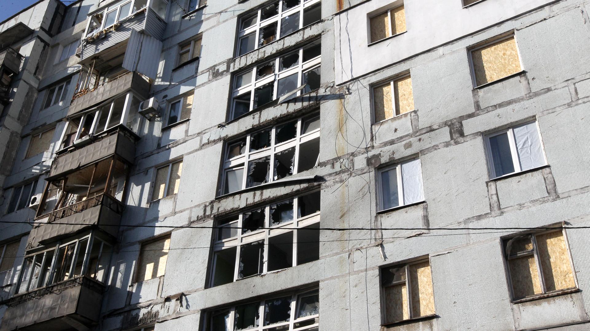 OSB-Platten verschließen die durch den russischen Drohnenangriff zerstörten Fenster eines Wohnhochhauses in Dnipro, Ukraine, am 25. November 2025.