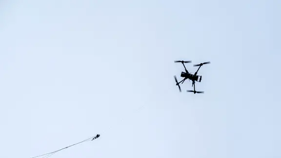 Eine Drohne der Bundespolizei fängt eine kleine Drohne mit einem Netz. | dpa, Sina Schuldt Eine Drohne der Bundespolizei fängt eine kleine Drohne mit einem Netz.