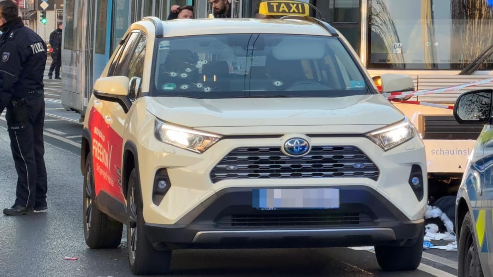 Auf der Windschutzscheibe des Taxis sind zehn Einschusslöcher zu erkennen