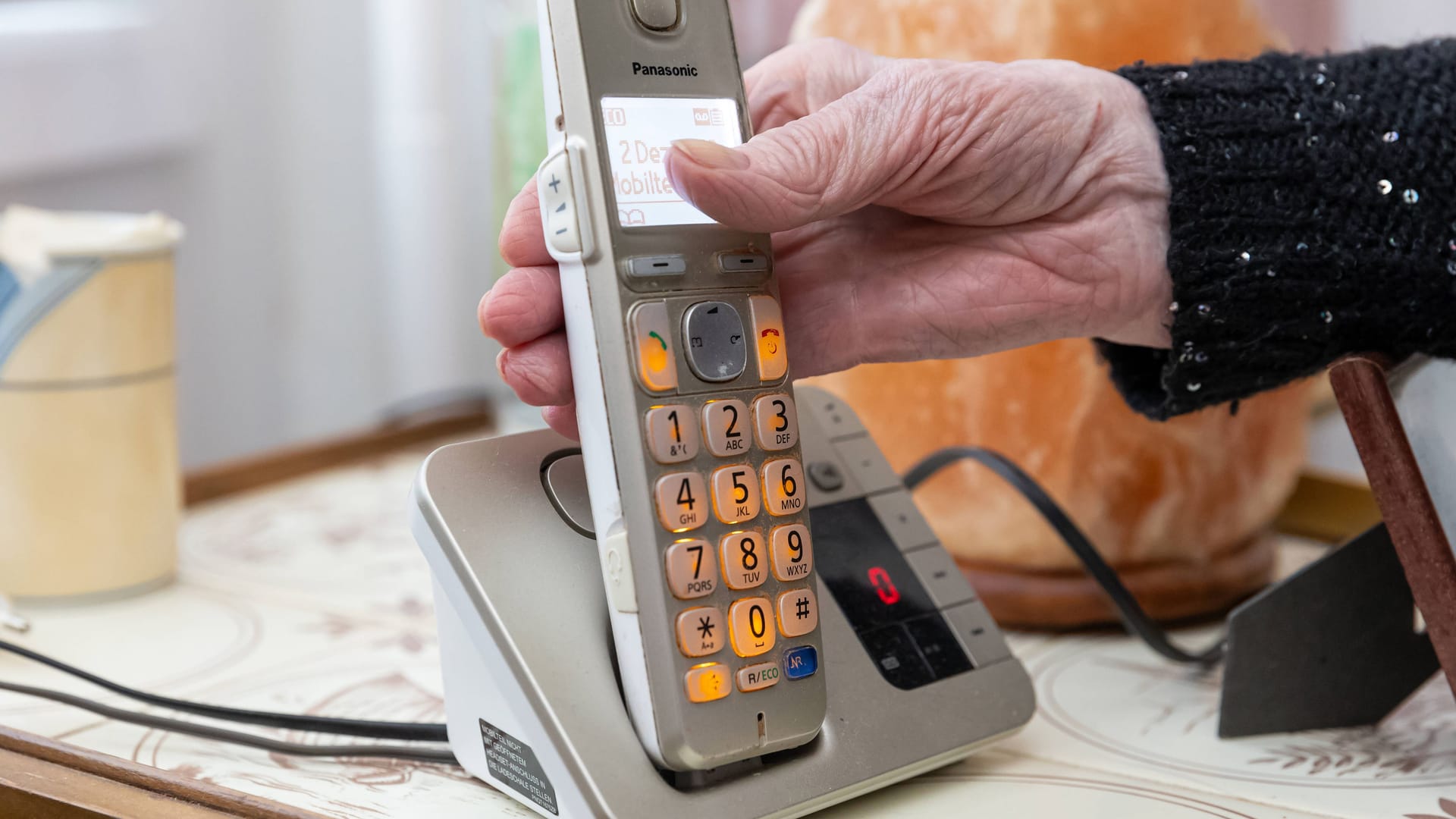 Eine Seniorin greift zum Telefon (Archivbild): In Dresden waren Betrüger erfolgreich.