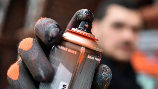 Eine Sprühdose wird in die Kamera gehalten