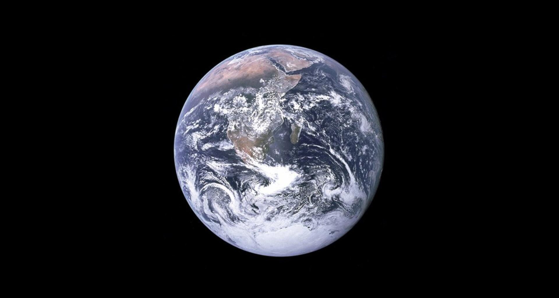 Die sonnenbeleuchtete Erde ist in Großaufnahme im sonst schwarzen Weltall zu sehen.