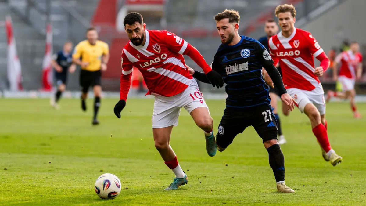 Energie Cottbus - MSV Duisburg: 06.12.2025, Brandenburg, Cottbus: Fußball: 3. Liga, Energie Cottbus - MSV Duisburg, 17. Spieltag, LEAG Energie Stadion. Tolcay Cigerci (l, Energie Cottbus) im Zweikampf mit Can Coskun (MSV Duisburg). Foto: Julius Frick/dpa +++ dpa-Bildfunk +++