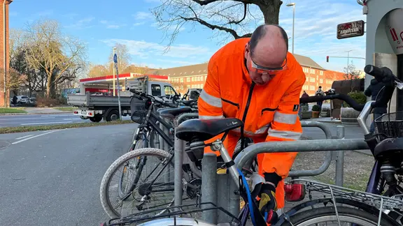 Ein Mann sammelt Schrotträder ein.