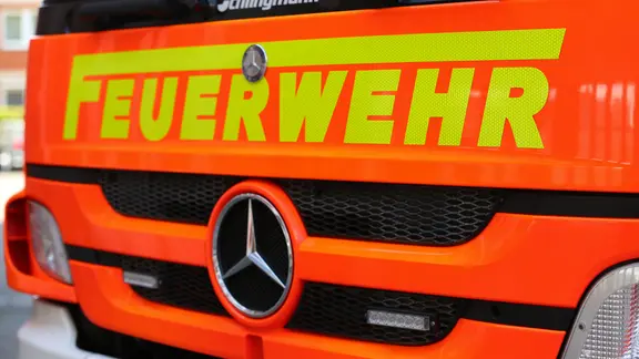 Schriftzug "Feuerwehr" ist auf der roten Motorhaube eines Feuerwehrautos zu sehen.